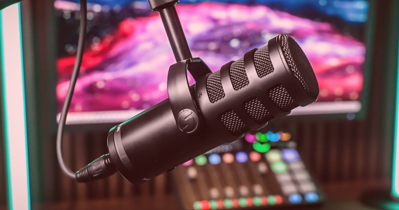 Close-up do microfone dinâmico híbrido Samson Q9U, destacando sua construção profissional em metal e o windscreen integrado, ideal para podcast e streaming com som de broadcast.