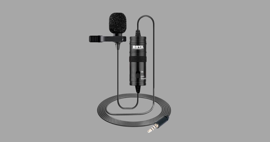 Conexão correta do microfone Boya BY-M1 na entrada 'MIC' de uma câmera DSLR, com o switch no modo 'Câmera', passo essencial para gravações de vídeo com áudio de qualidade.
