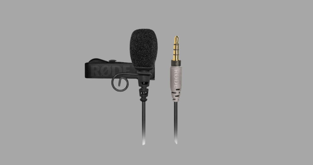 Demonstração do conector TRRS do Rode SmartLav+ ao lado do adaptador RØDE SC3, ilustrando o acessório necessário para conectar o microfone a câmeras DSLR, um ponto crucial nesta análise de versatilidade.