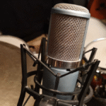 Microfone condensador multi-padrão AKG P420 em seu shock mount, destacando seu design profissional para estúdio.