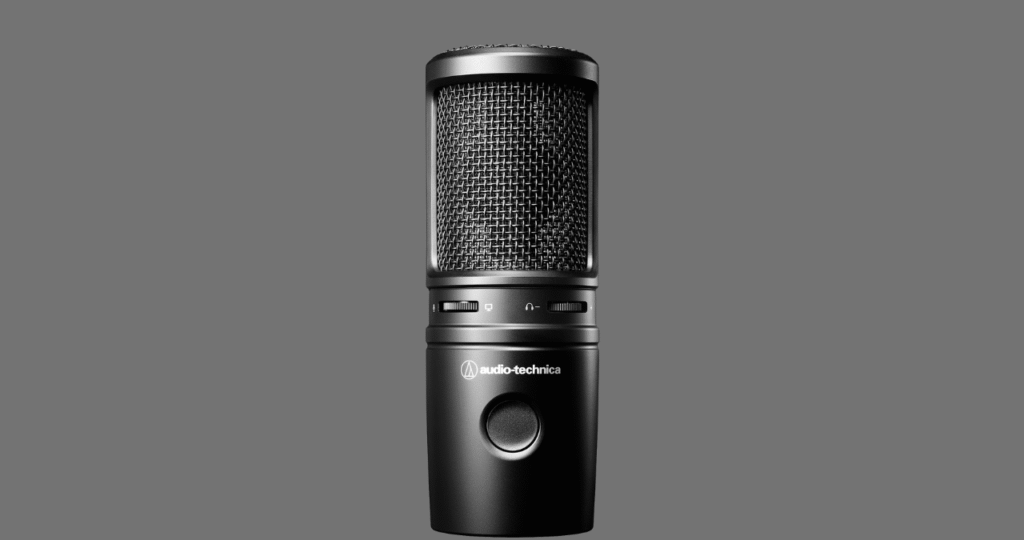 Microfone Audio-Technica AT2020 montado em um braço articulado sobre uma mesa, em um setup ideal para podcast e streaming.