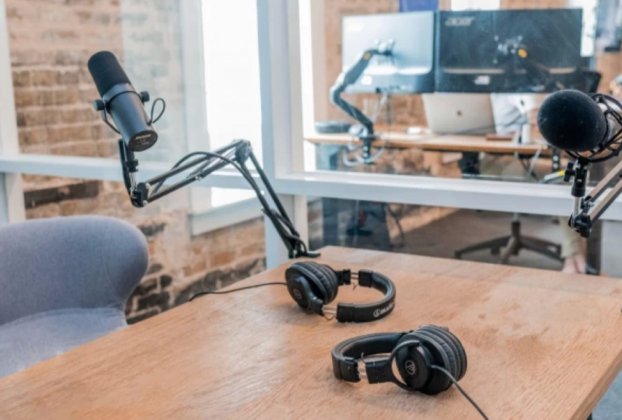 Uma bancada de estúdio de gravação profissional exibindo os quatro melhores microfones para podcast analisados no artigo: Shure SM7B, Rode ProCaster, Rode NT-USB e Blue Yeti, prontos para transmissão.