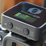 Sistema de microfone sem fio Rode Wireless PRO completo em seu estojo de carregamento inteligente aberto, exibindo os transmissores, o receptor com tela OLED e os microfones de lapela Lavalier II.