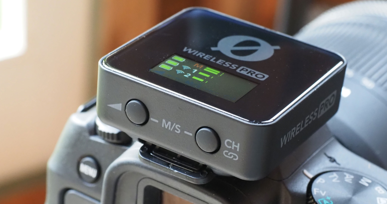 Sistema de microfone sem fio Rode Wireless PRO completo em seu estojo de carregamento inteligente aberto, exibindo os transmissores, o receptor com tela OLED e os microfones de lapela Lavalier II.